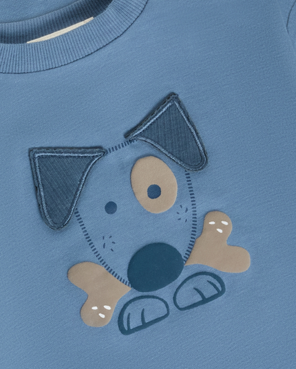 A close-up of a blue children's sweatshirt featuring a dog applique on the front. 