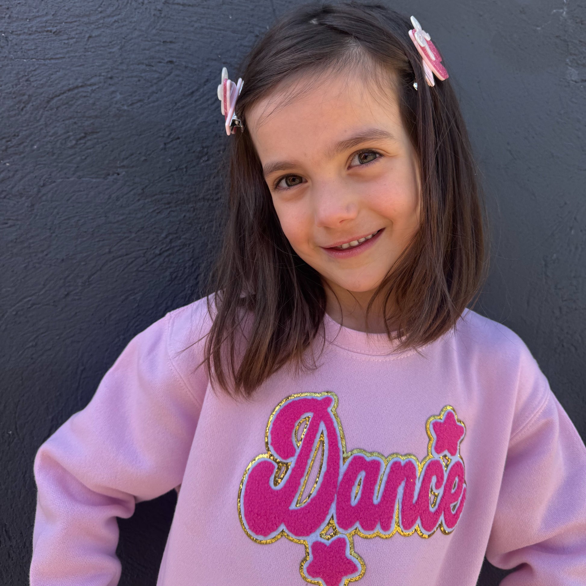 Girl wearing pink dance patch sweatshirt