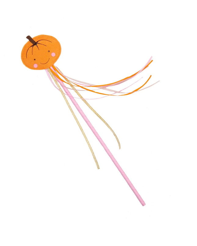 A whimsical smiling pumpkin wand with colorful ribbon streamers