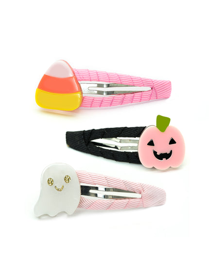 Three Halloween-themed hair clips: a pink candy corn clip, a black jack-o'-lantern clip, and a pink ghost clip.