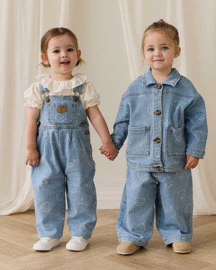 Two children wearing blue denim outfits with bear pattern