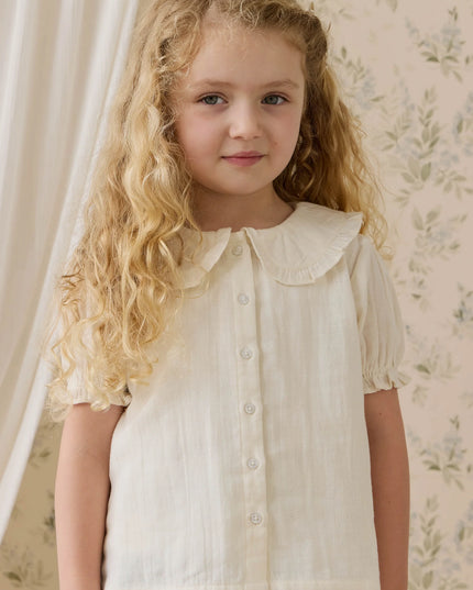 Girls wearing white button down blouse with ruffled collar and sleeves