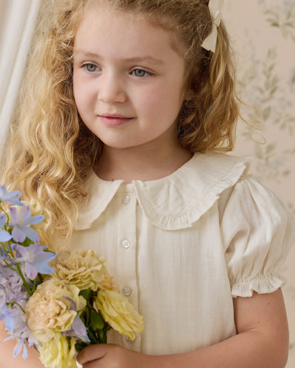 Girls wearing white button down blouse with ruffled collar and sleeves