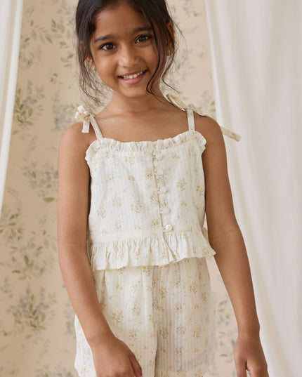 Girl wearing cream and floral top and shorts