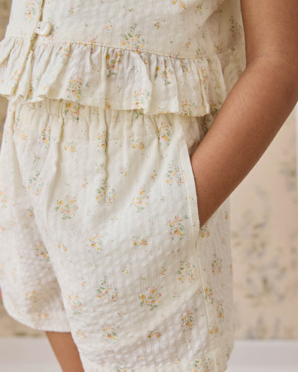 Girl wearing cream shorts with floral pattern