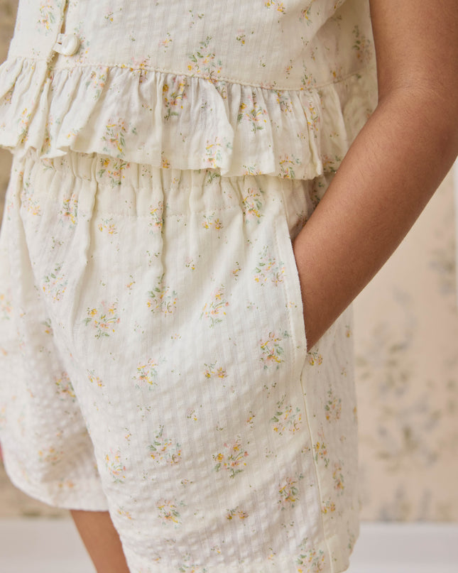 Girl wearing cream shorts with floral pattern