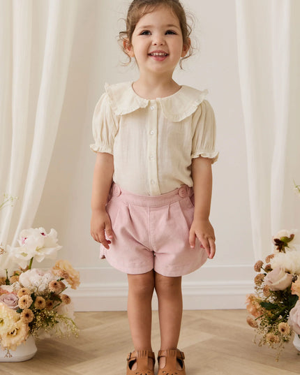 Girls wearing white button down blouse with ruffled collar and sleeves
