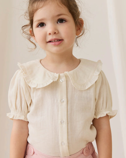 Girls wearing white button down blouse with ruffled collar and sleeves