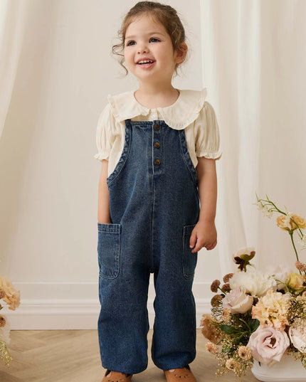 Girl wearing white blouse with blue denim overalls