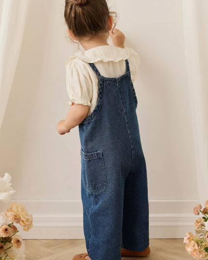 Girl wearing white blouse with blue denim overalls