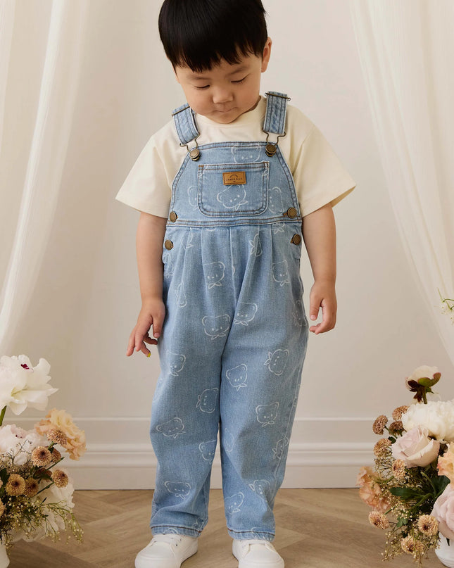 Child wearing blue denim overalls with bear pattern