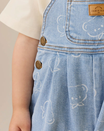 Child wearing blue denim overalls with bear pattern