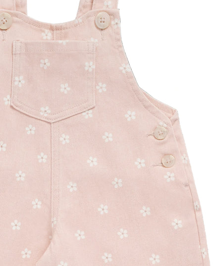 Closeup of pink overalls with white flowers