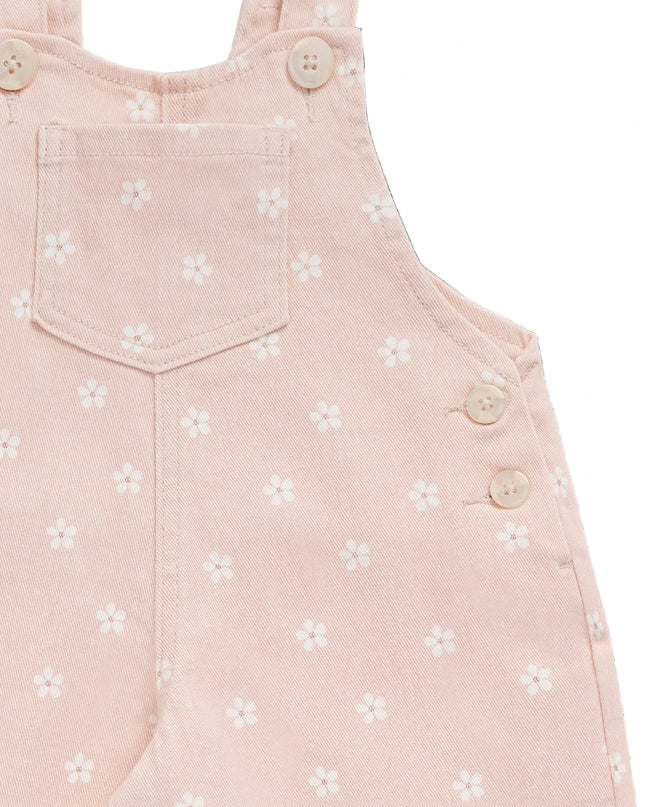 Closeup of pink overalls with white flowers