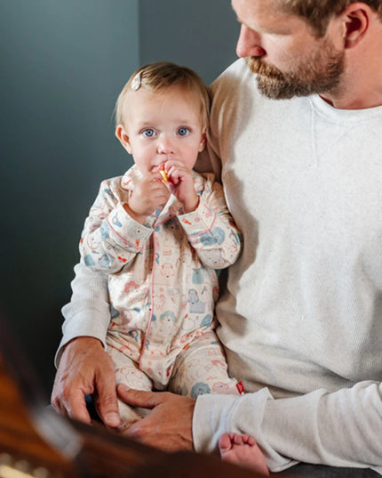 Baby wearing coverall pajamas with poodle print 
