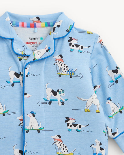 A light blue long-sleeve pajama coverall with a cartoon dog pattern on roller skates, featuring a collar and magnetic closure.