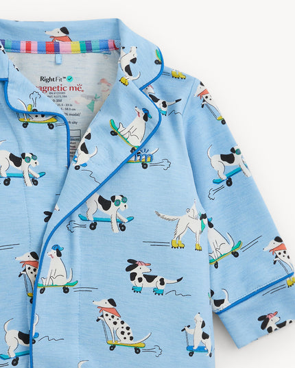 A light blue long-sleeve pajama coverall with a cartoon dog pattern on roller skates, featuring a collar and magnetic closure.