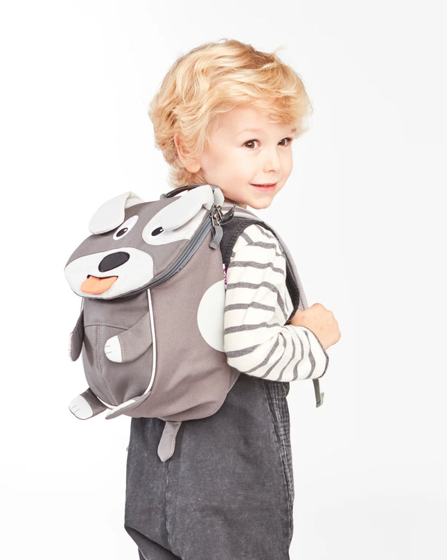 Child wearing a gray dog backpack