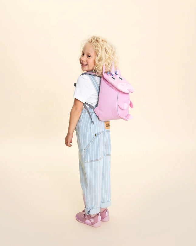 A child wearing a pink unicorn-shaped backpack 