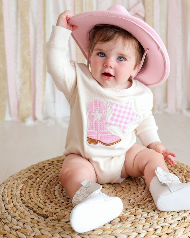 Baby wearing romper with cowboy boot and star patch