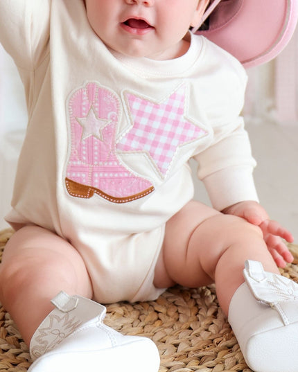 Baby wearing romper with cowboy boot and star patch