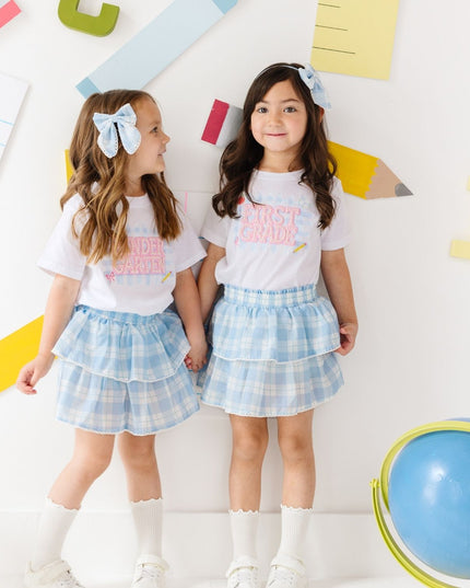 Girls wearing pearl patch school t-shirts and plaid skirts
