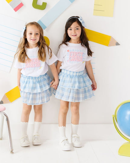 Girls wearing pearl patch school t-shirts and plaid skirts