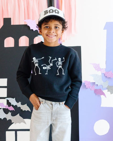 Boy wearing Black Sweatshirt with dancing skeletons and "boy" trucker hat