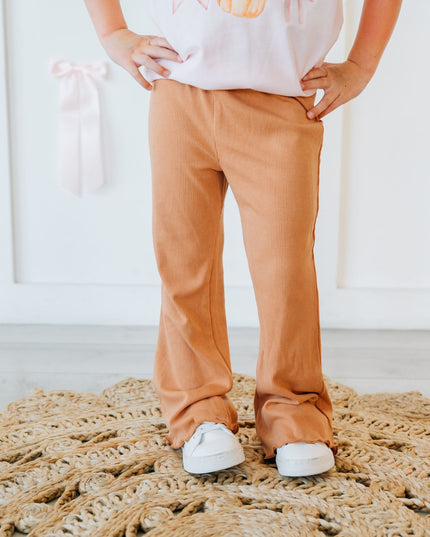 A child wearing burnt orange flare ribbed leggings