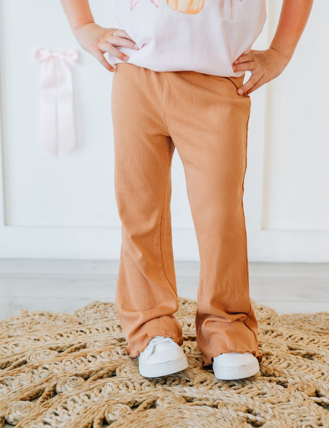 A child wearing burnt orange flare ribbed leggings
