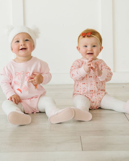 Baby wearing pink Rompers with fun Christmas graphics