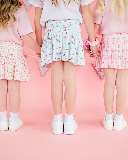 Three children wearing floral athletic skorts