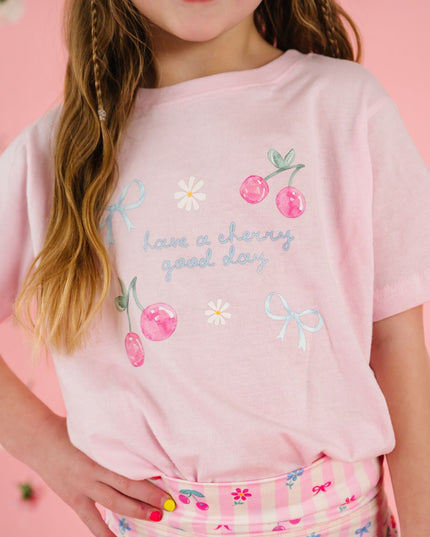 girl wearing pink t-shirt with cherry and bow designs