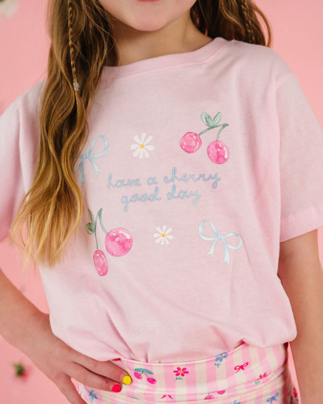 girl wearing pink t-shirt with cherry and bow designs