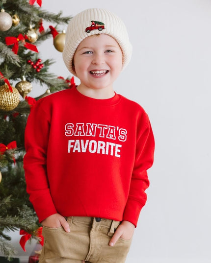 Boy wearing red sweatshirt with 'Santa's Favorite' graphic