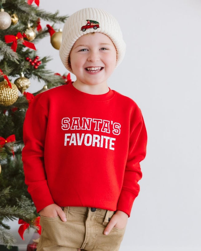 Boy wearing red sweatshirt with 'Santa's Favorite' graphic