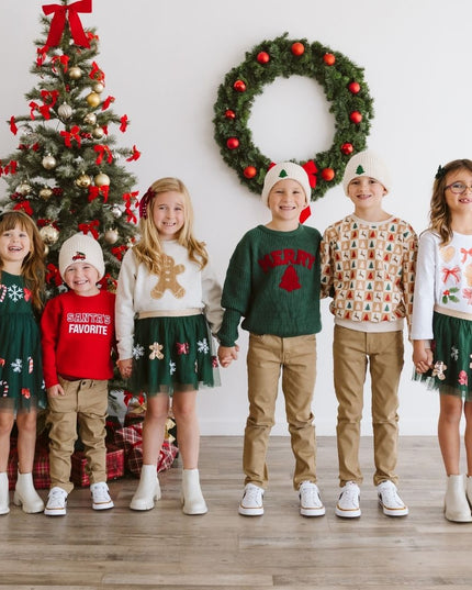 Kids wearing festive Christmas outfits. 