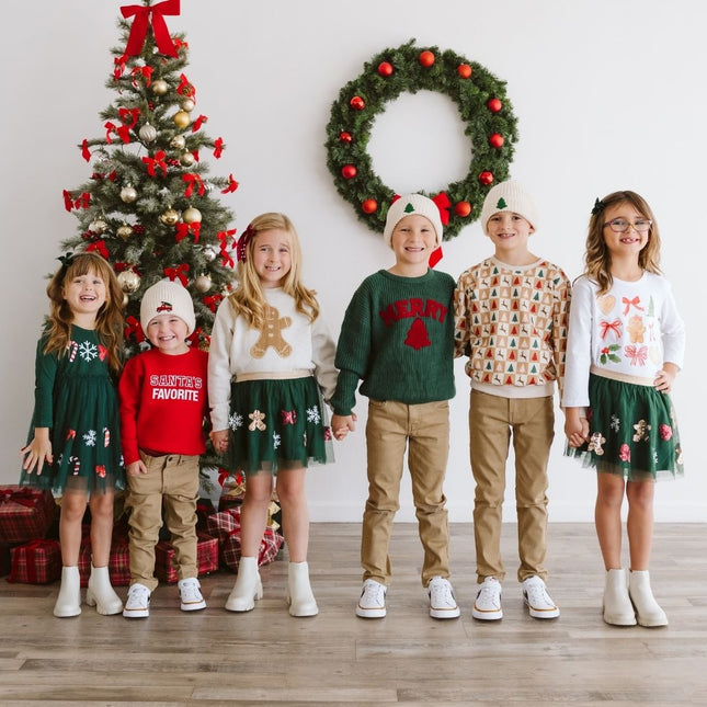 Kids wearing festive Christmas outfits. 