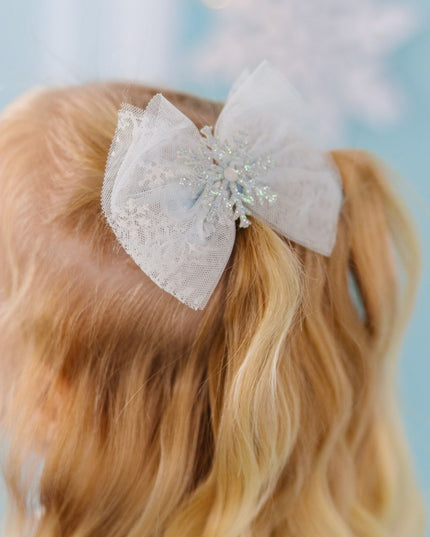 Girl wearing a blue tulle with glitter snowflake hair clip