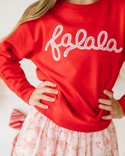 girl wearing red falala sweatshirt and candy cane skirt