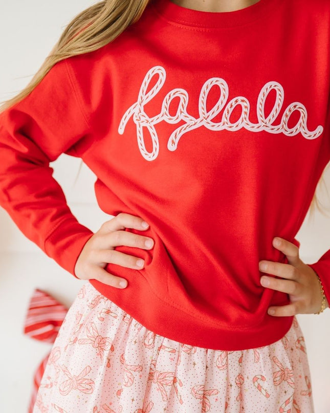 girl wearing red falala sweatshirt and candy cane skirt