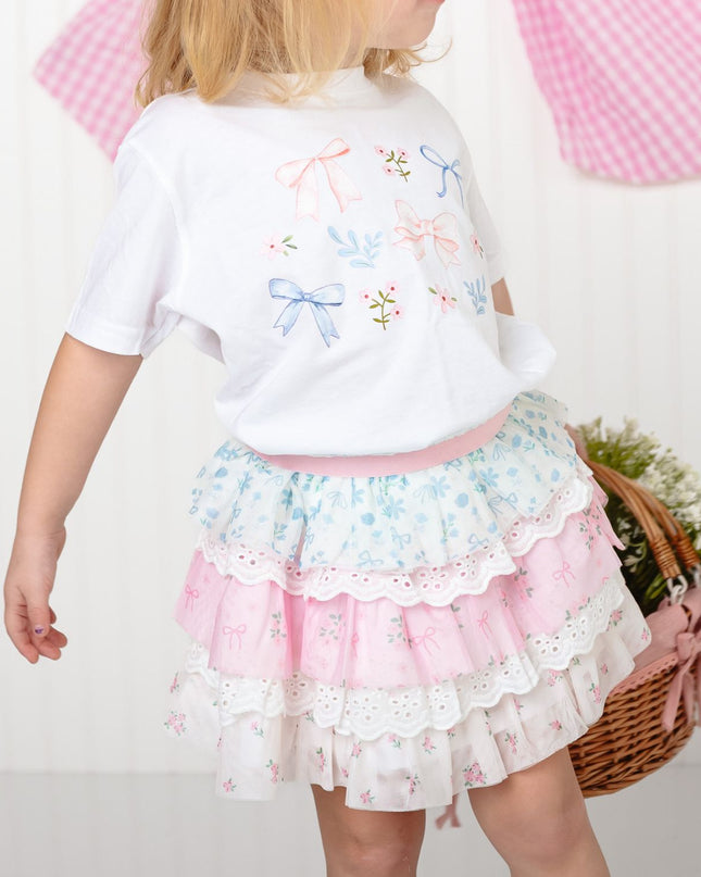 Girl wearing whit t-shirt with bows and floral and lace tiered tutu