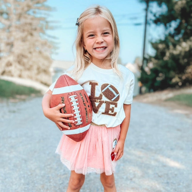 Girl holding a football and wearing "Love" Football Patch Short Sleeve T-Shirt