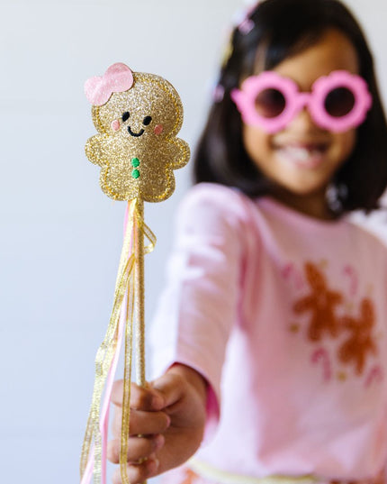 Girl holding gold gingerbread Christmas wand
