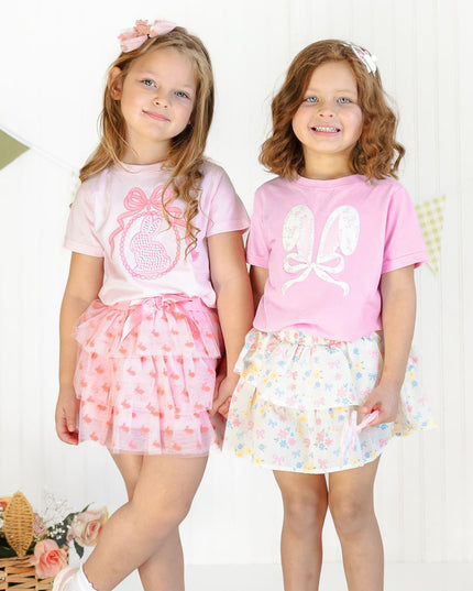 Two girls wearing pink and floral spring outfits