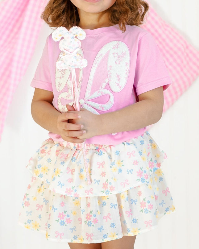 Girl wearing pink t-shirt with lace bow bunny ears patch and floral skirt