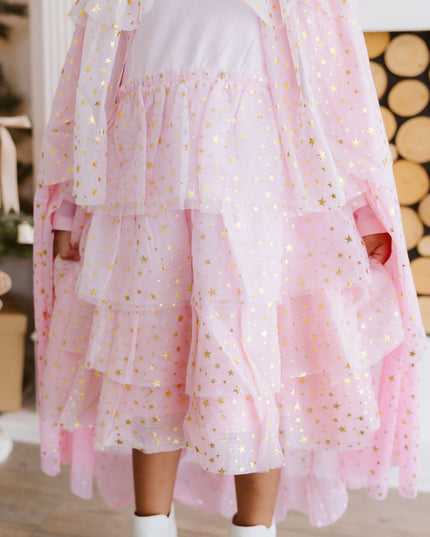 Girl wearing light pink tutu dress and cape with gold stars 