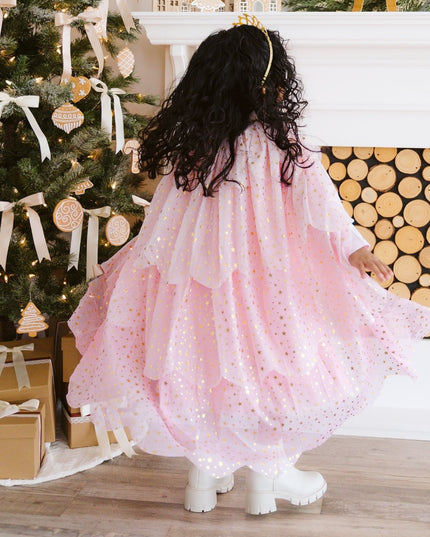 Girl twirling wearing blush pink tiered cape with gold stars
