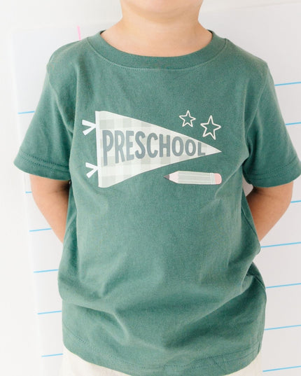Boy wearing Green t-shirt with 'preschool' banner 
