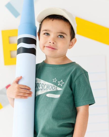 Boy wearing Green t-shirt with 'preschool' banner 